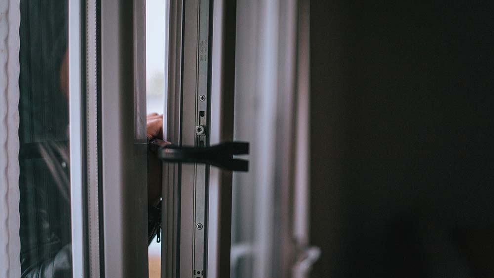 A person using a crowbar to open a door